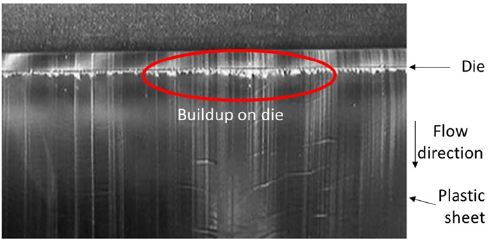 Figure 6 - Molten polyethylene is pushed through a metal die to form thin sheets for later thermoforming of liners. Plate-out or “die drool” seen here is the buildup of additives on the die and can later sluff off onto the plastic.